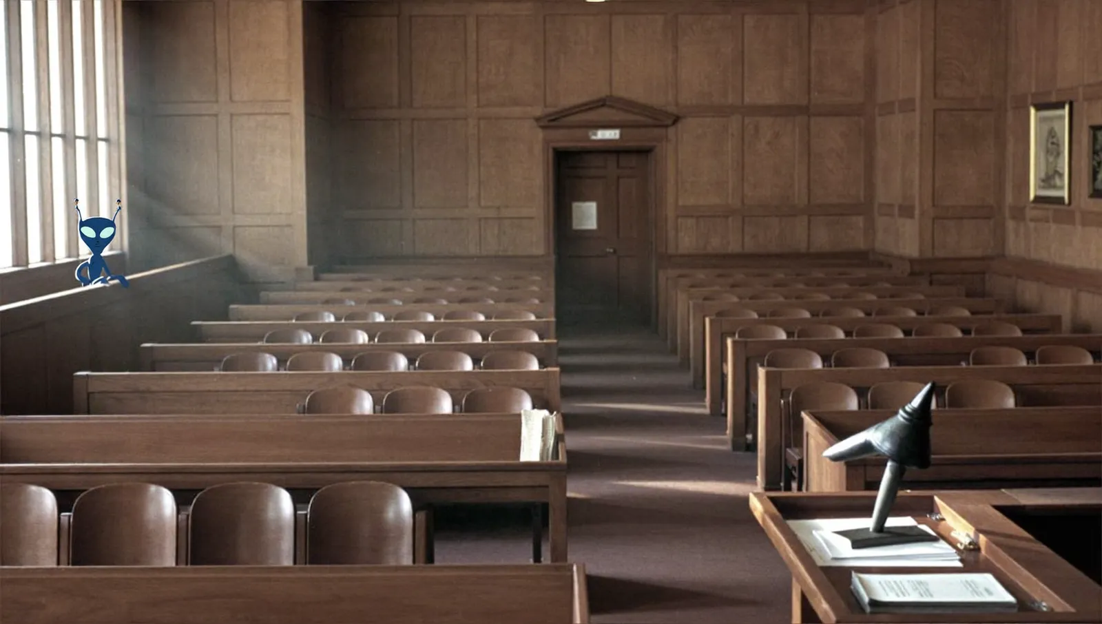 An empty wood-panelled American federal courtroom in the mid-1980s with vacant benches and afternoon light through tall windows