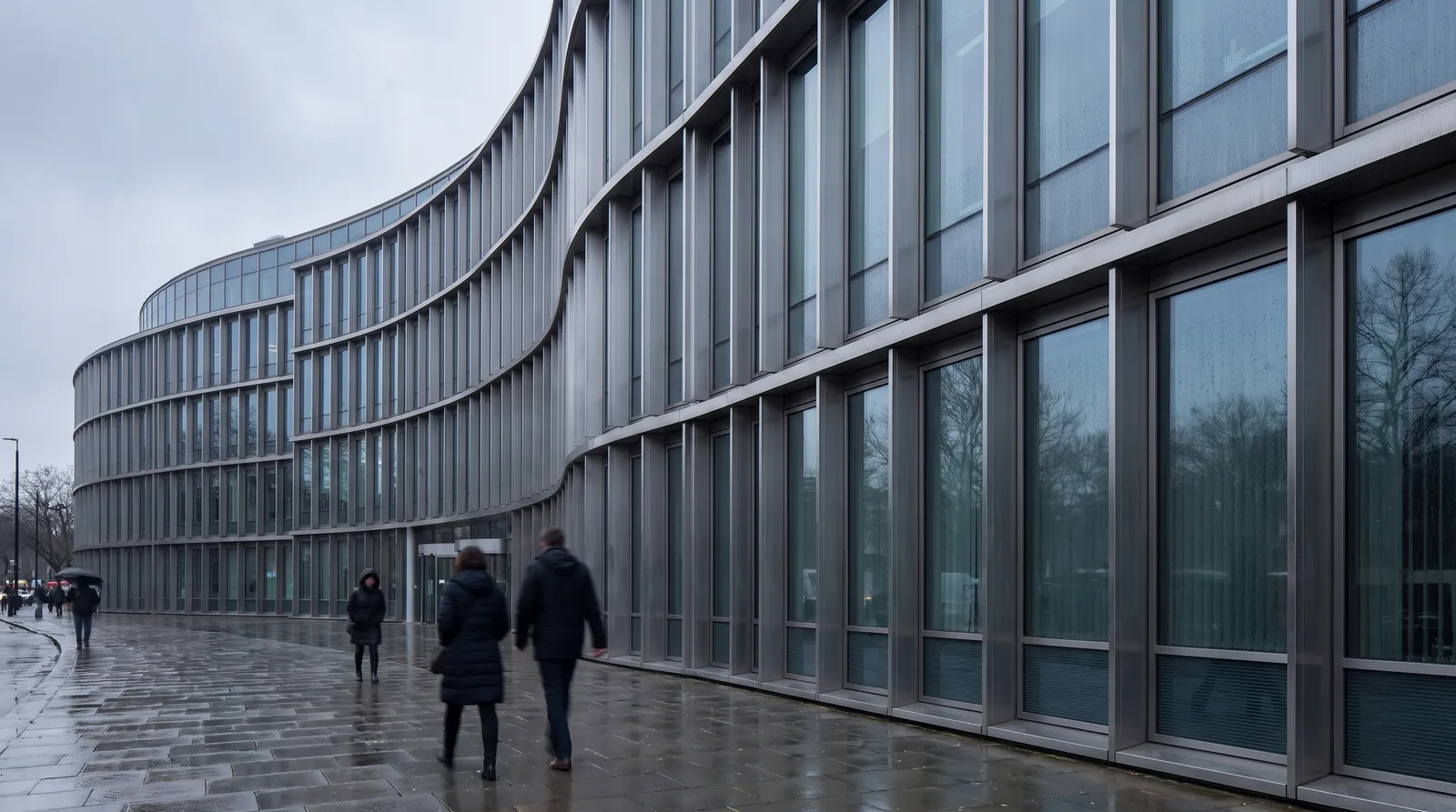The curved glass and steel facade of a large modern European institutional building on an overcast day, anonymous figures walking past